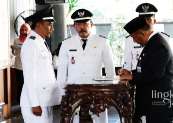 SIMBOLIS: Pj Bupati Pati Henggar Budi Anggoro menandatangani SK pelantikan PAW Kades Mojo belum lama ini. (Dok. Humas Pemkab Pati/Lingkarjateng.id)