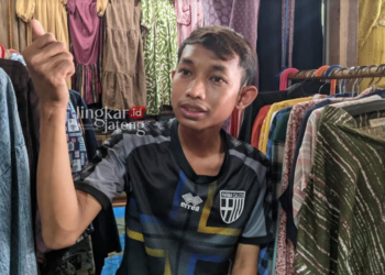 MENERANGKAN: Rizky Bachtiar (29) Warga Desa Waru Kecamatan Rembang saat ditemui ditempat kerjanya di salah satu kios di pasar induk Rembang. (R Teguh Wibowo/Lingkarjateng.id)
