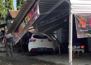 MENABRAK: Mobil matic berplat nomor H 9258 K menabrak tiang salah satu toko hingga patah. (Istimewa/Lingkarjateng.id)