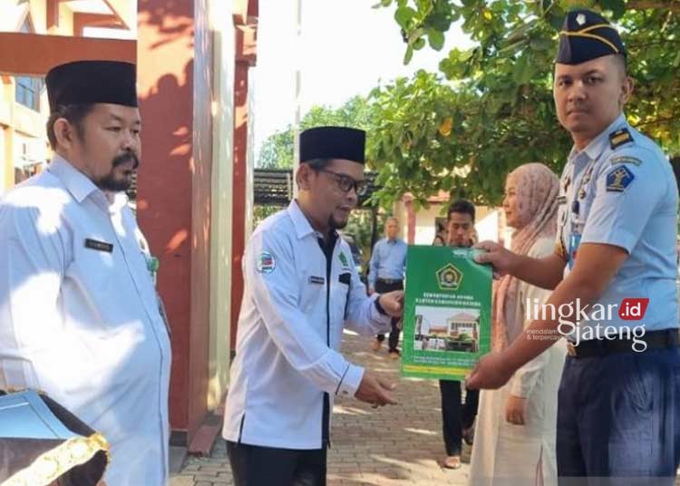 SIMBOLIS: Kepala Kementerian Agama Batang, Akhmad Farhan secara simbolis menyerahkan sertifikasi halal pada petugas Lapas Kelas II B Rowobelang, Batang. (Istimewa/Lingkarjateng.id)