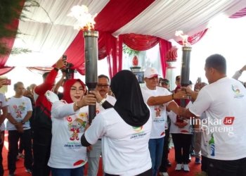 Bupati Grobogan Harap Api Abadi Mrapen Bakar Semangat Kontingen Porprov Jateng 31 MEMBARA: Bupati Grobogan Sri Sumarni didampingi Ketua KONI Grobogan Fatchur Rahman menyerahkan obor api kepada dua atlet Grobogan. (Eko Wicaksono/Lingkarjateng.id)