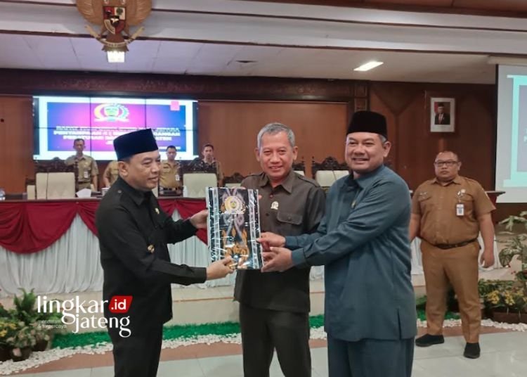 SIMBOLIS: Pj Bupati Jepara Edy Supriyanta (kiri) saat menyerahkan empat raperda kepada dua perwakilan DPRD Jepara di Ruang Rapat Graha Paripurna DPRD Jepara pada Senin, 28 Agustus 2023. (Tomi Budianto/Lingkarjateng.id)