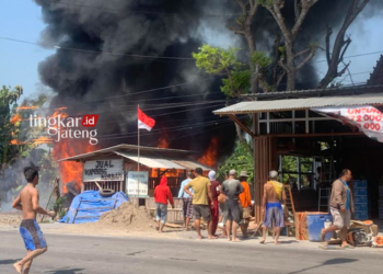 BERKOBAR: Warga berhamburan memadamkan api yang melahap gudang milik Wahyudi di Desa Kedungori Dempet Demak. (M Burhanuddin Aslam/Lingkarjateng.id)