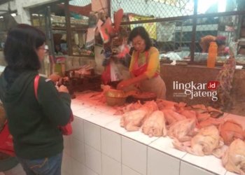 JUAL BELI: Pedagang daging ayam di Pasar Raya Salatiga tengah melayani pembeli. (Angga Rosa/Lingkarjateng.id)