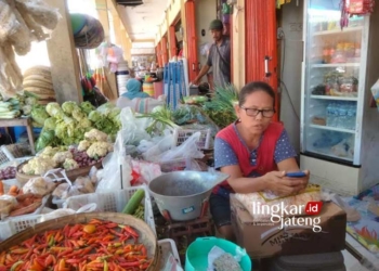 BERJUALAN: Salah satu pedagang Pasar Randublatung, Tin, yang pernah diperiksa Kejari Blora terkait kasus dugaan jual beli kios pasar setempat. (Hanafi/Lingkarjateng.id)