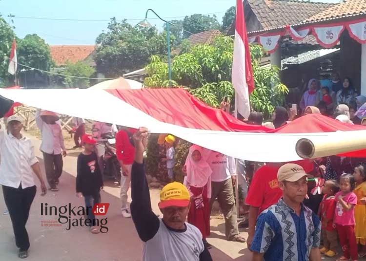 SEMANGAT: Desa Kalirandugede, Kecamatan Cepiring, Kabupaten Kendal membawa bendera merah putih ukuran besar memeriahkan karnaval mandiri pada Minggu, 27 Agustus 2023. (Unggul Priambodo/Lingkarjateng.id)