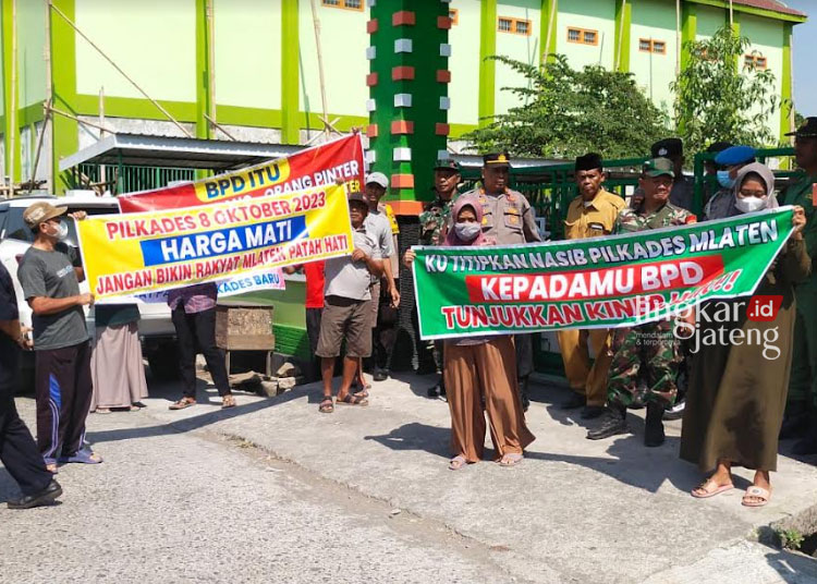 DEMONSTRASI: Ratusan warga Desa Mlaten membawa banner atau spanduk bertuliskan tuntutan kepada Pemdes Desa Mlaten, Senin, 14 Agustus 2023. (M Burhanuddin Aslam/Lingkarjateng.id)