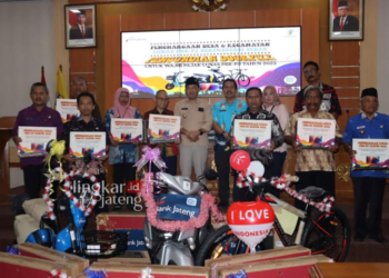 GEMBIRA: Pj Bupati Jepara Edy Supriyanta dan para wajib pajak foto bersama di Gedung Ratu Shima Jepara, Kamis, 24 Agustus 2023 usai penyerahan hadiah. (Tomi Budianto/Lingkarjateng.id)