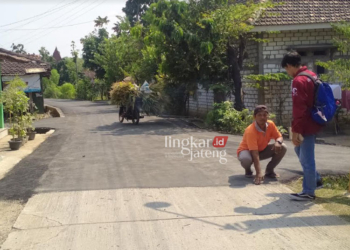 SUDAH MULUS: Warga Desa Sokopuluhan, Kecamatan Pucakwangi, Kabupaten Pati menunjukkan jalan yang sudah bagus kemudian ditimpa dengan aspal tipis. (Khairul Mishbah/Lingkarjateng.id)
