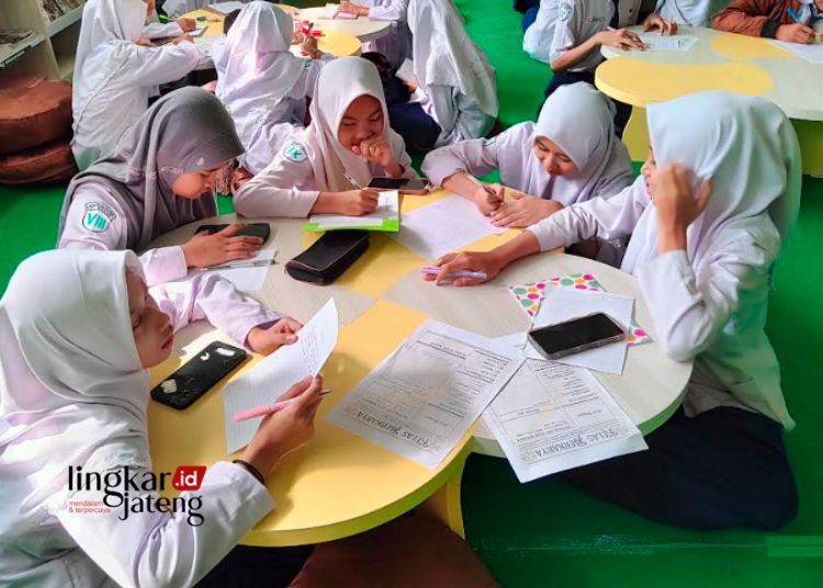 KERJA KELOMPOK: Sejumlah peserta didik terlihat sedang mengerjakan tugas di salah satu perpustakaan di Kabupaten Kudus. (Ihza Fajar/Lingkarjateng.id)