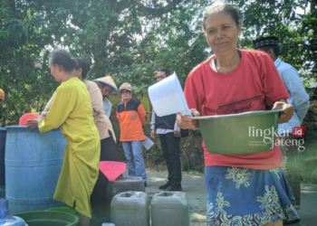 BERBONDONG-BONDONG: Warga Dukuh Pelem, Desa Sendangasri, Kecamatan Lasem, Kabupaten Rembang mengisi wadah dengan air bersih dari BPBD Rembang, baru-baru ini. (R Teguh Wibowo/Lingkarjateng.id)
