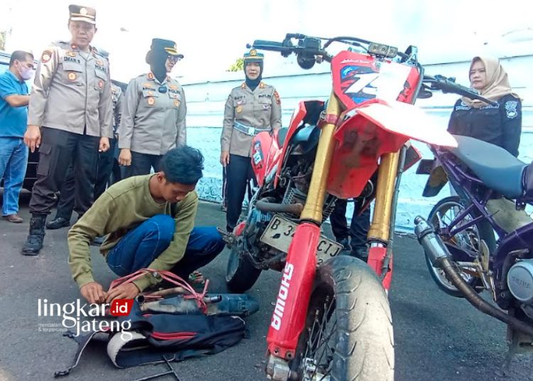 KENA SANKSI: Salah satu pengendara motor dengan knalpot brong terjaring razia diminta diganti dengan knalpot standarisasi pabrik oleh Satlantas Polres Salatiga pada Selasa, 19 September 2023. (Angga Rosa/Lingkarjateng.id)