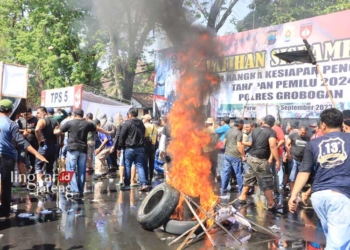 MEMANAS: Ratusan massa melakukan simulasi demo hasil Pemilu 2024 dengan membakar ban di Alun-Alun Purwodadi, Grobogan. (Eko Wicaksono/Lingkarjateng.id)