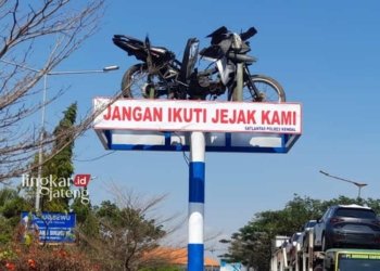 MONUMEN: Sepeda motor ringsek korban kecelkaan lalu lintas terpajang di Perempatan Ungup-Ungup sebelum masuk Jalur Lingkar Weleri Kendal. (Arvian Maulana/Lingkarjateng.id)