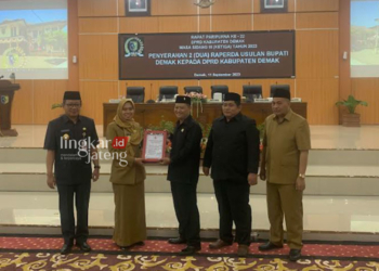 SIMBOLIS: Bupati Demak Eisti’anah menyerahkan Raperda tentang Kawasan Tanpa Rokok kepada Ketua DPRD Kabupaten Demak Fahrudin Bisri Slamet di ruang rapat paripurna DPRD Demak, Senin, 11 September 2023. (M. Burhanuddin Aslam/Lingkarjateng.id)