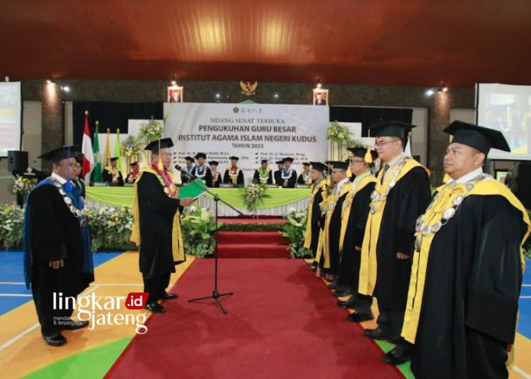 SIMBOLIS: Rektor IAIN Kudus Prof. Abdurrahman Kasdi saat mengukuhkan enam guru besar di GOR IAIN Kudus pada Sabtu, 23 September 2023. (Nisa Hafizhotus. S/Lingkarjateng.id)