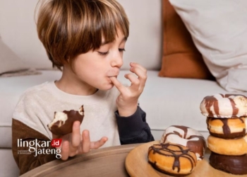 ILUSTRASI: Seorang anak memakan makanan manis. (Freepik/Lingkarjateng.id)