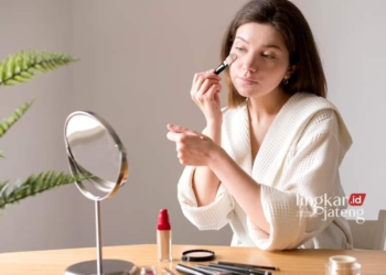 ILUSTRASI: Seorang wanita yang sedang mengenakan make up. (Freepik/Lingkarjateng.id)