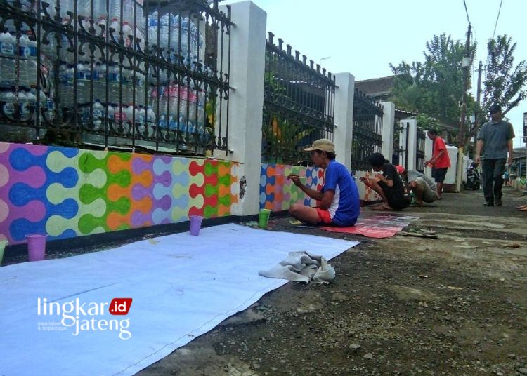 BERKARYA: Warga Kampung Pancuran, Kelurahan Kutowinangun Lor, Kecamatan Tingkir, Kota Salatiga melukis pagar menuju kampung asri. (Dok. Instagram kampungpancuran/Lingkarjateng.id)