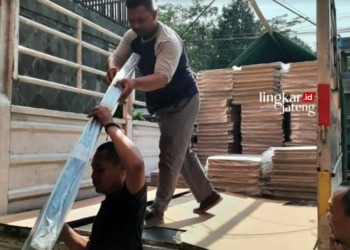 MENDISTRIBUSIKAN: Dua orang pekerja menurunkan bilik suara Pemilu 2024 dari truk untuk disimpan di gudang KPU Salatiga pada Jumat, 20 Oktober 2023. (Dok. Kpu Salatiga/Lingkarjateng.id)