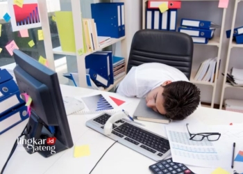 TERTIDUR: Seorang karyawan tertidur karena kelelahan bekerja. (Freepik @namii9/Lingkarjateng.id)