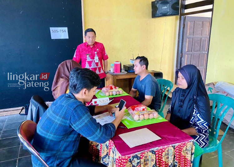 MONITORING: Camat Tuntang, Aris Setyawan (baju merah) saat meninjau penyaluran bantuan pangan kepada keluarga dengan anak stunting dan keluarga miskin di Balai Desa Kesongo, Kecamatan Tuntang, Kabupaten Semarang, Kamis, 26 Oktober 2023. (Hesty Imaniar/Lingkarjateng.id)