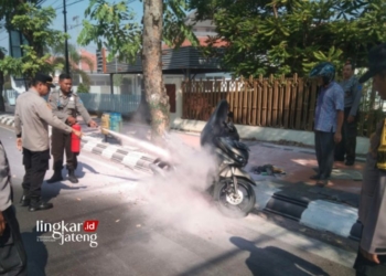 MEMADAMKAN API: Petugas Polsek Kudus Kota memadamkan api yang tiba-tiba terbakar saat dikendarai di Jalan Sudirman turut Desa Keramat, Kecamatan Kota, Kabupaten Kudus pada Rabu, 18 Oktober 2023. (Ihza Fajar/Lingkarjateng.id)