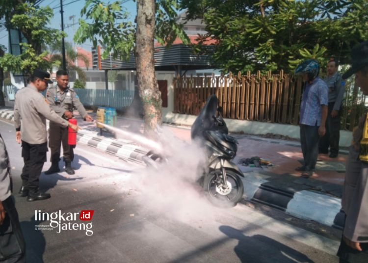 MEMADAMKAN API: Petugas Polsek Kudus Kota memadamkan api yang tiba-tiba terbakar saat dikendarai di Jalan Sudirman turut Desa Keramat, Kecamatan Kota, Kabupaten Kudus pada Rabu, 18 Oktober 2023. (Ihza Fajar/Lingkarjateng.id)
