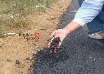 MENUNJUKKAN: Warga memperlihatkan kondisi jalan di Dusun Gawuhan, Desa Genting Gunung yang ambyar. (Unggul Priambodo/Lingkarjateng.id)