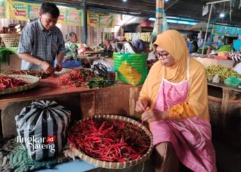 MENYORTIR: Pedagang di Pasar Blauran Salatiga memilah cabai yang kurang baik sembari menunggu konsumen pada Kamis, 19 Oktober 2023. (Angga Rosa/Lingkarjateng.id)