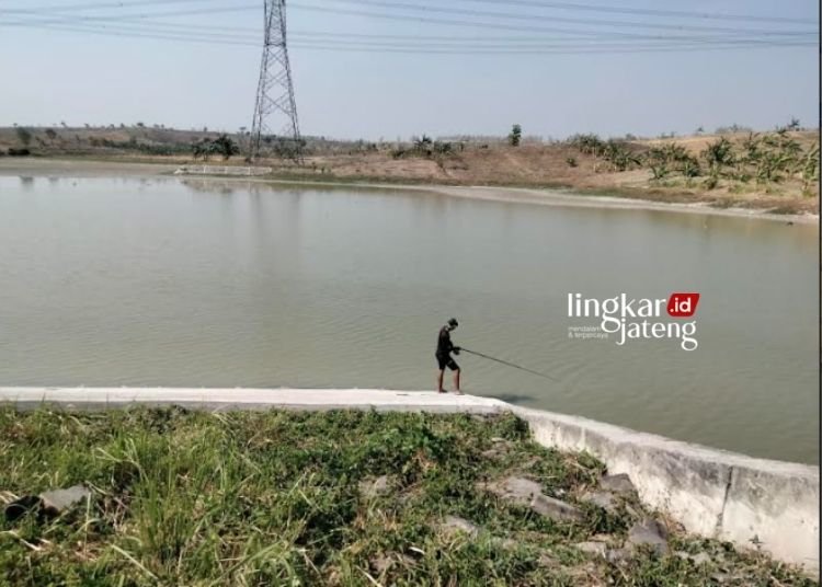 MEMANCING: Seorag warga sedang memancing di Bendungan Keruk, Dukuh Keruk, Kelurahan/Kecamatan Randublatung, Kabupaten Blora. (Hanafi/Lingkarjateng.id)