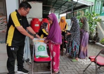 DISTRIBUSI: Plh Lurah Kajeksan, Muchlisin, saat membagikan beras kepada warga di kantor kelurahan setempat pada Jumat, 20 Oktober 2023. (Nisa Hafizhotus. S/Lingkarjateng.id)