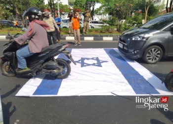 DEMONSTRASI: Bendera Israel dilindas kendaraan sebagai bentuk protes beberapa ormas di Semarang pada Jumat, 20 Oktober 2023. (Rizky Syahrul Al-Fath/Lingkarjateng.id)