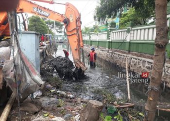 ANTISIPASI BANJIR: Pengerukan sedimen di saluran Jalan Kaligawe Raya terus dilakukan. (Rizky Syahrul Al-Fath/Lingkarjateng.id)