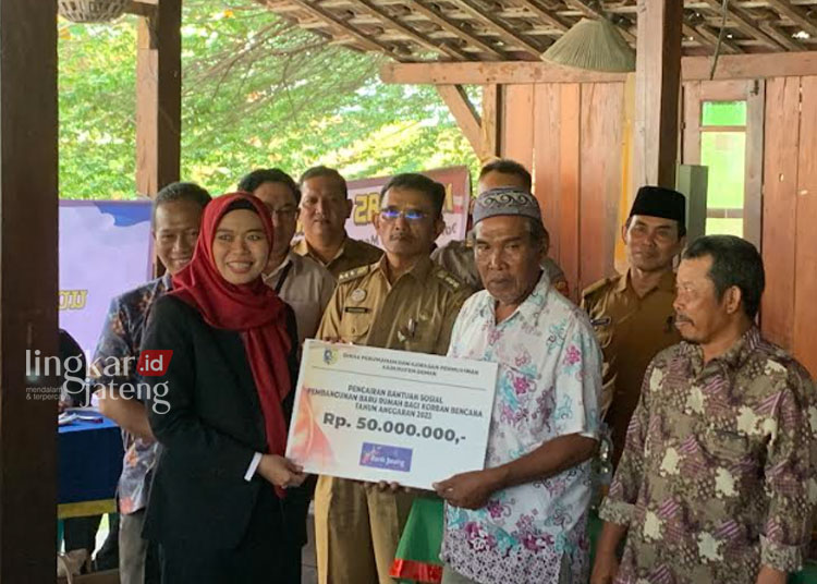 SIMBOLIS: Bupati Eisti’anah (jilbab merah) menyerahkan bantuan sosial pembangunan baru bagi korban bencana dan relokasi Kabupaten Demak, Senin, 6 November 2023. (M. Burhanuddin Aslam/Lingkarjateng.id)