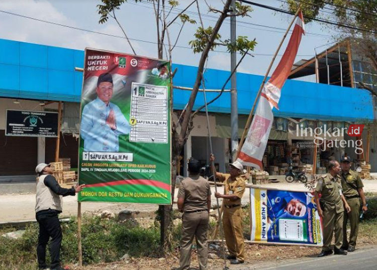 PENCOPOTAN: Tim gabungan melakukan penertiban alat peraga kampanye di Jalan Mejobo, Kabupaten Kudus, baru-baru ini. (Antara/Lingkarjateng.id)