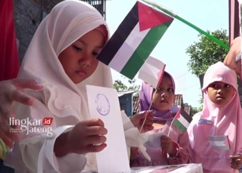 PEDULI: Pelajar RA IT Al-Firdaus Gubug, Grobogan memasukkan amplop berisi uang saku ke dalam kardus donasi untuk Palestina. (Dok. Pribadi for Lingkar/Lingkarjateng.id)