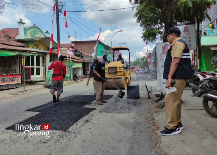 PENGASPALAN: Tampak sejumlah pekerja dari Dinas PUPR sedang melakukan perbaikan salah satu ruas jalan di Kabupaten Kudus, belum lama ini. (Nisa Hafizhotus. S/Lingkarjateng.id)