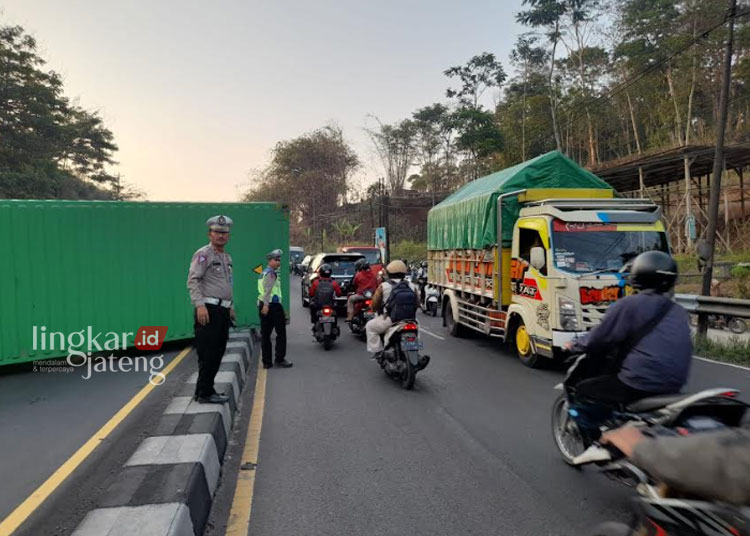 MELINTANG: Sejumlah petugas dari Satlantas Polres Semarang melakukan conter flow, akibat tergulingnya sebuah kendaraan truk kontainer di tanjakan Mangkelang, Kelurahan Asinan, Kecamatan Bawen, Kabupaten Semarang atau tepatnya di ruas Jalan Salatiga-Bawen, pada Rabu petang, 11 November 2023. (Hesty Imaniar/Lingkarjateng.id)