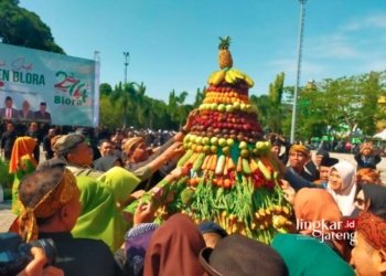 BEREBUT: Pelajar dan warga Blora berebut jajanan dan sayuran dalam Grebeg Gunungan di Alun-Alun Blora usai upacara Hari Jadi Blora ke-274 pada Senin, 11 Desember 2023. (Subekan/Lingkarjateng.id)