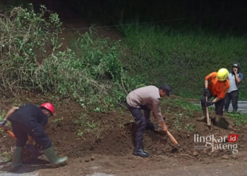 KERJA BAKTI: Petugas BPBD dan Polres Salatiga membersihkan material longsoran tanah yang menutup medan jalan lingkar selatan (JLS), tepatnya di daerah Kumpulrejo, Argomulyo, beberapa waktu lalu. (Angga Rosa/Lingkarjateng.id)