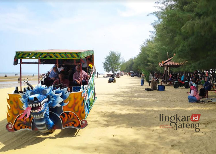 ASYIK BERLIBUR: Sejumlah pengunjung objek wisata Pantai KJB sedang menaiki wahana kereta wisata. (R.Teguh Wibowo/Lingkarjateng.id)