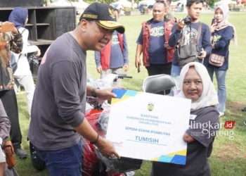EMPATI: Pj Bupati Jepara Edy Supriyanta saat menyerahkan bantuan bimbingan pemberdayaan kepada disabilitas dalam peringatan Hari Disabilitas Internasional (HDI) Tahun 2023 di Alun-Alun 1 Jepara, pada Minggu, 3 Desember 2023. (Humas Jepara for Lingkar/Lingkarjateng.id)