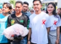 MENYAPA MASYARAKAT: Ketua Umum PSI, Kaesang Pangarep kedua dari kanan) bersama istri Erina Gudono (kanan) foto bersama warga yang mendapat 10 kilogram ikan gratis dari nelayan saat CFD di Alun-Alun Kabupaten Pati pada Minggu, 17 Desember 2023. (Arif Febriyanto/Lingkarjateng.id)