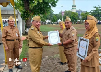 SIMBOLIS: Wakil Bupati Kendal, Windu Suko Basuki, menyerahkan piagam penghargaan pengelolaan sistem informasi DOKAR. (Arvian Maulana/Lingkarjateng.id)