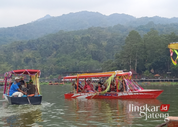 MAIN WAHANA: Sebuah kapal wisata di Danau Rawa Pening, Kecamatan Tuntang, Kabupaten Semarang tengah beroperasi. (Hesty Imaniar/Lingkarjateng.id)