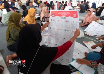 MEMERIKSA: Tenaga sorlip di gudang logistik KPU Kendal di gudang Islamic Center Bugangin Kendal memeriksa surat suara. (Arvian Maulana/Lingkarjateng.id)