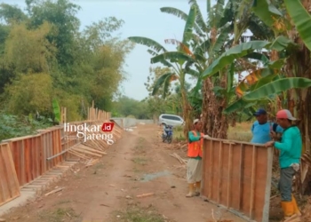 GOTONG ROYONG: Tampak warga turut memasang parapet beton di sepanjang Sungai Blorong, Kendal untuk mengantisipasi limpasan air. (Robison/Lingkarjateng.id)