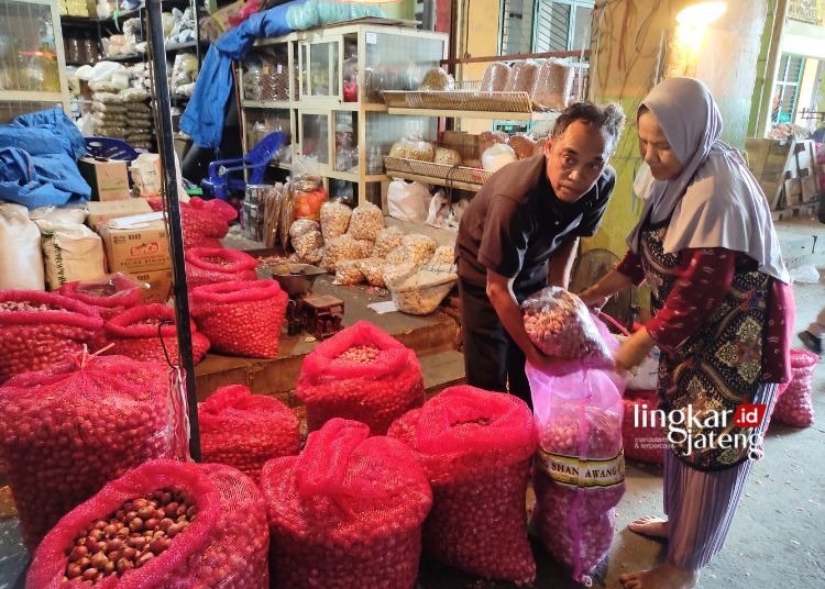 BEKERJA: Tampak pedagang bawang merah menyortir dagangannya di Pasar Bitingan, Kabupaten Kudus. (Nisa Hafizhotus. S/Lingkarjateng.id)