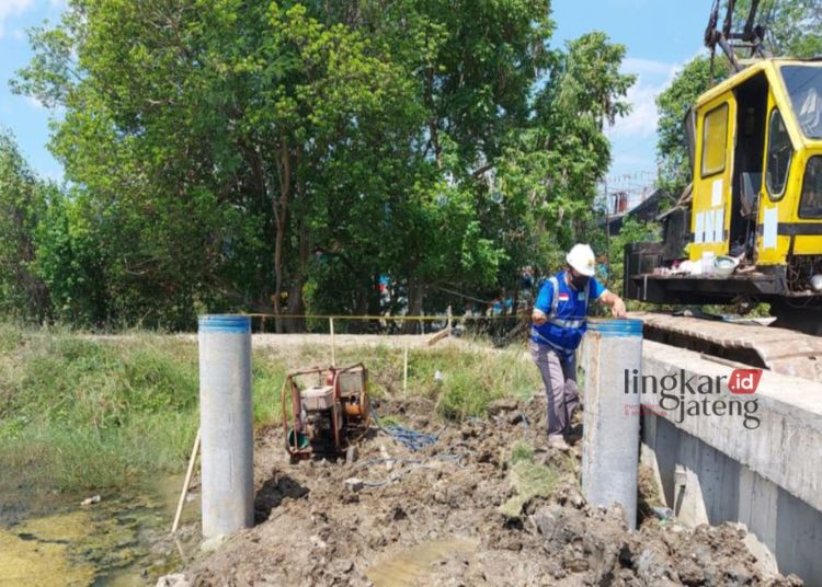 BEKERJA: Seorang petugas terlihat sedang melakukan pengukuran di area proyek tambat kapal Pelabuhan Juwana, Kecamatan Juwana, Kabupaten Pati. (Arif Febriyanto/Lingkarjateng.id)
